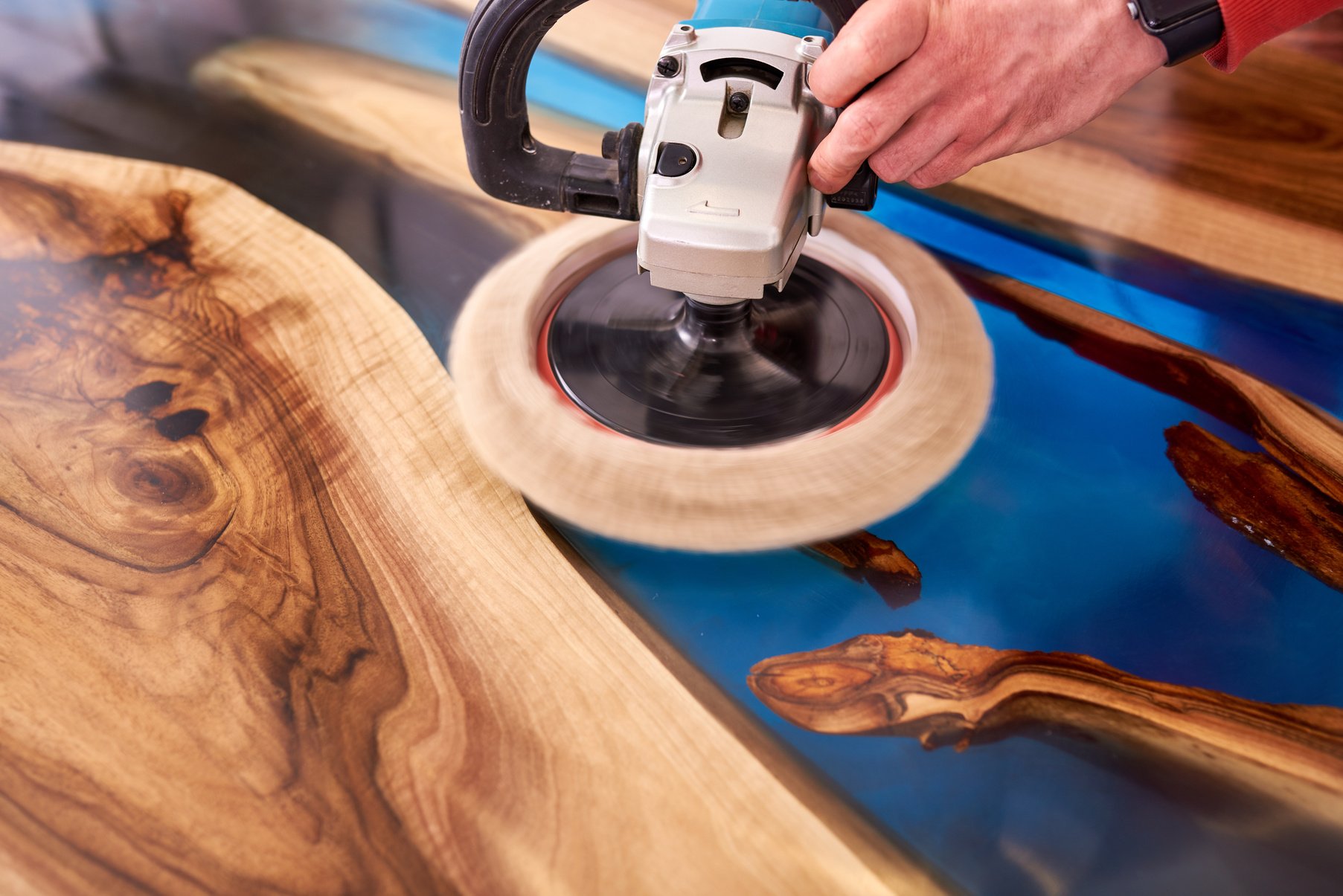 man polishing epoxy table close up